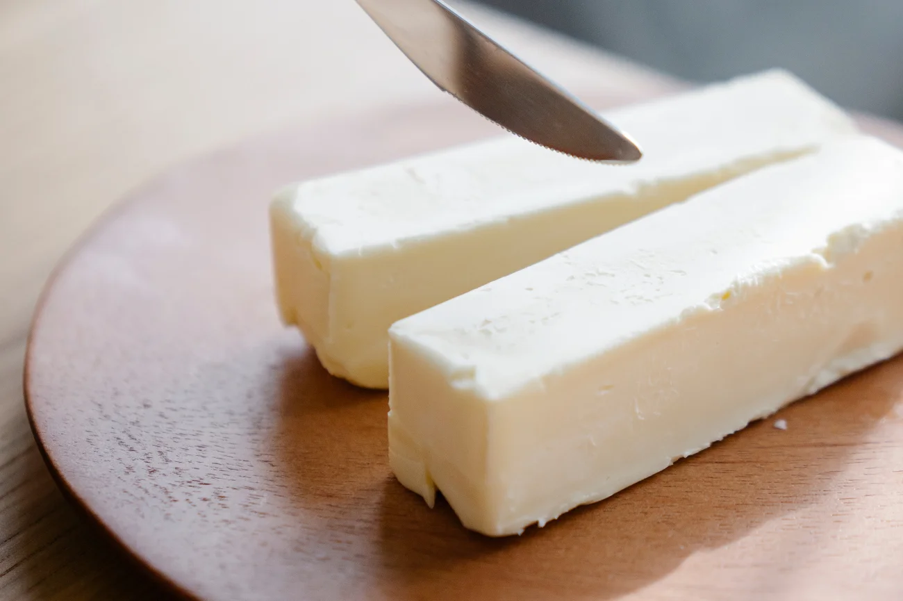 Masło to popularny produkt spożywczy w Polsce Masło na drewnianej okrągłej desce